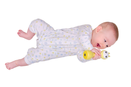 Happy baby plays lying on the floor with toys, isolated on a white background. Four month old child on the white carpet holding a toy in his hands