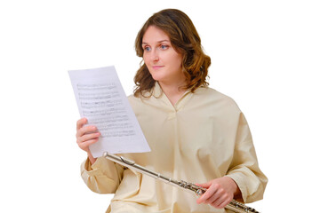 Woman musician with flute looks at notes on sofa in living room, isolated on a white background