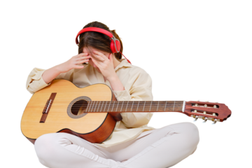 A shamed crying woman with acoustic guitar sitting on a bed in a home living room, isolated on a white background