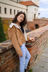 Mongolian young woman in a historic Czech city. Fashion tourist concept. 