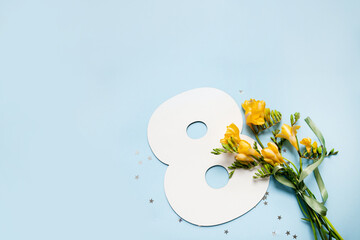 
number 8 shape layout with yellow flowers bouquet on blue background. copy space. top view. concept of international women's day. March 8. - obrazy, fototapety, plakaty