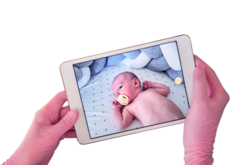 The doctor takes a video on a tablet with a newborn baby, isolated on a white background. A nurse conducts an online consultation on the treatment of a child. Kid aged two months