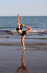 young girl during training by the sea in summer with shorts