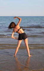 girl during training by the sea in summer with shorts