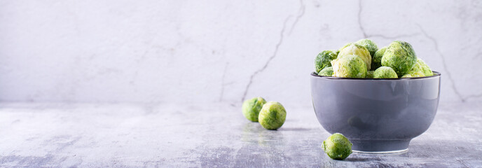 A bowl of frozen brussels sprouts on the table. Vegetable diet. Web banner