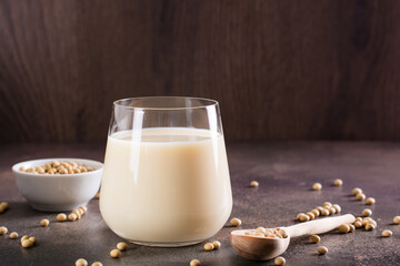 Soy milk in a glass and soybeans in a bowl on the table. Lactose free drink.