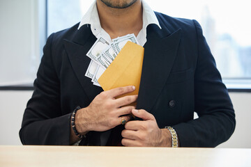 close up the man putting money in envelope into his suit pocket