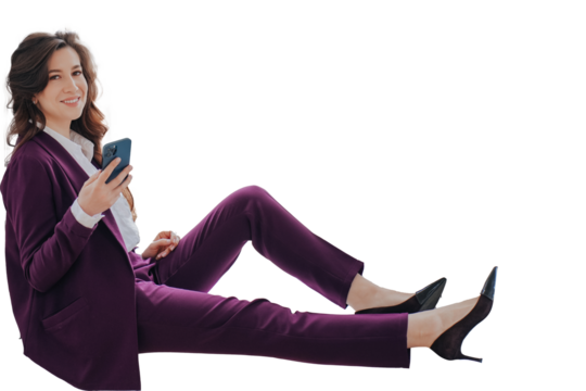 Cheerful brunette businesswoman in violet suit sits against transparent background holds phone, talks via video call. Gorgeous smiley lawyer happy to completed the case. Cheerful teacher having break
