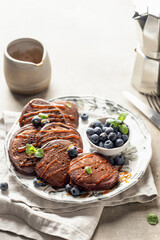 Healthy breakfast. Pancakes with fresh blueberries and mint leaves served with coffee in morning light