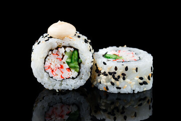 Sushi rolls with crab sticks, cucumber in sesame seeds and sauce. © smspsy