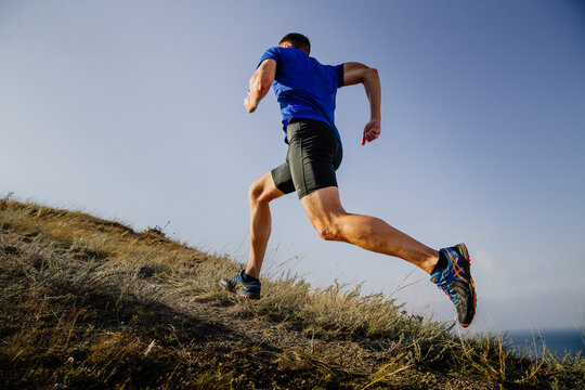 Sochi, Russia -  September 19, 2017: male runner running uphill trail in Asics shoes