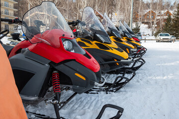 Parking of snowmobiles in a mountain village in winter