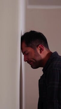 Video of person leaning his head against a wall, worried, stressed, with many problems, pensive, resigned, frustrated. Concept of lifestyles, problems, societal problems.