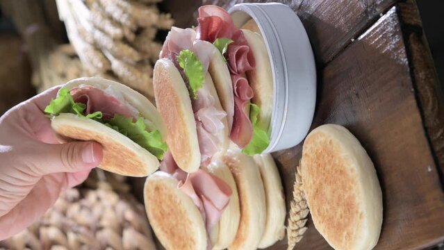 tigelle or crescentine homemade, con prosciutto, salame, stracciatella liquida. Italian food typical of the area of Modena, Emilia-Romagna. Thin round breads stuffed with prosciutto. 4k footage