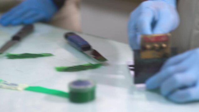 Someone spreading green color for sample test at paint factory