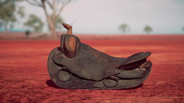 Old decorated mexican saddle lying on sand