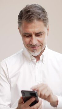 Middle age businessman in white business shirt. Casual entrepreneur using phone. Portrait of mid adult, mature age man, happy smiling. Isolated on white, copy space.