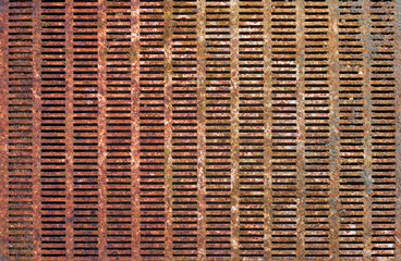 Rusty perforated metal sheet close-up. Iron surface with many holes - natural industrial background