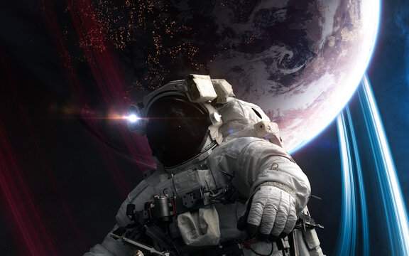 Astronaut in outer space in front of distant inhabited planet. Science fiction. Elements of this image furnished by NASA