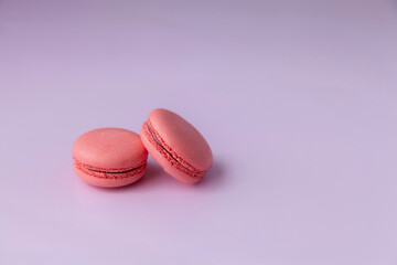 Two pink macaroons on pink background close up copy space