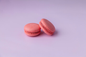 Two pink macaroons on pink background close up copy space