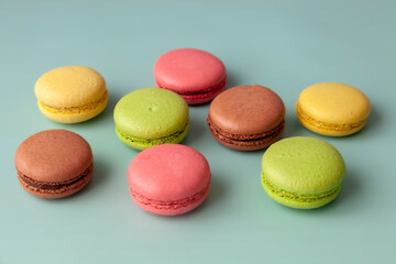 Multi color macaroons on turquoise background close up