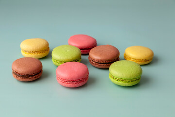 Multi color macaroons on turquoise background close up