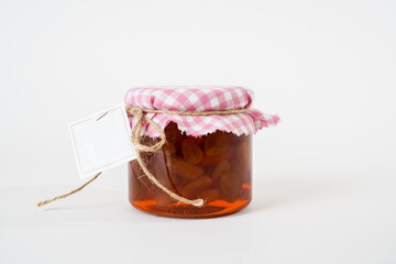 Jar of homemade grape jam with blank label isolated on white background.