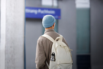 Young man with a backpack at a train station