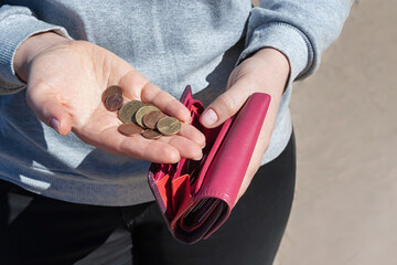 Pink purse and coins in female hands, selective focus.