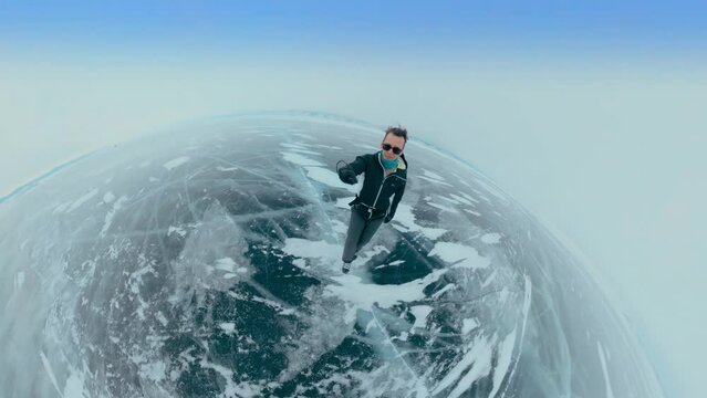 A young man skates on the ice of a frozen lake and takes selfies, Baikal, Siberia, Russia