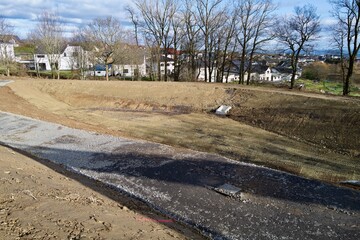 Neues Regenr&uuml;ckhaltebecken im Wohngebiet &mdash; Entw&auml;sserungsanlage mit Basaltschotter  in der Bauphase