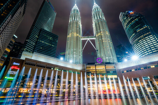Kuala Lumpur, Malaysia - January 2023: Every evening, the Petronas Twin Towers illuminate the plaza outside Suria Mall, accompanied by beautiful fountains and an amazing display of lights.