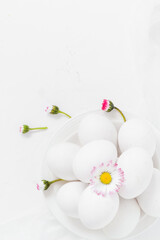 Obraz na płótnie Canvas Spring Easter background with white eggs Daisy flowers