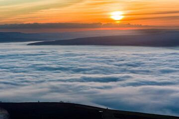 Sunset from a mountain top above a sea of fog