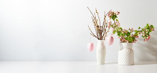 Spring flowers in a vase and easter eggs on a light background. Easter background with copy space