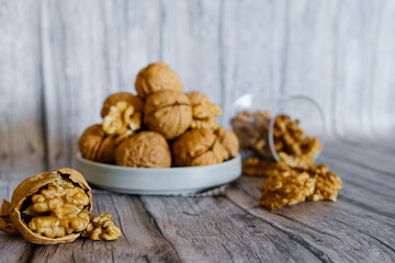 Fruta seca de noz em casca sobre mesa de madeira com desfoque