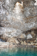 sun shining through opening in cave and basin