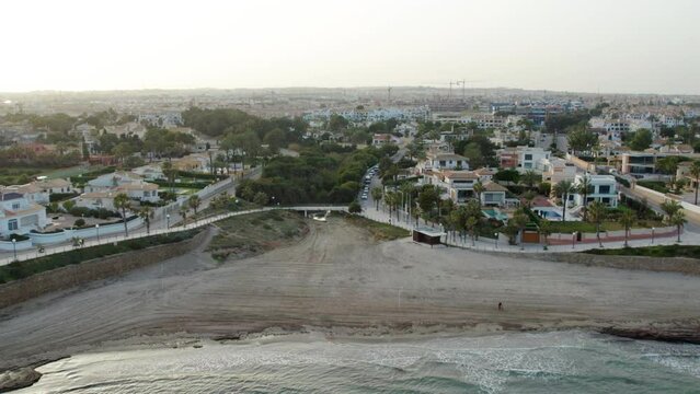 Drone point of view of coastal houses and seafront promenade in the Playa Flamenca. Costa Blanca. Province of Alicante. Spain. Travel and tourism concept