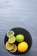 still life citrus fruits orange lemon lime lie on a tray on a gray background with room for text. Fruits benefit vitamins preparation of acidic water. health care vitamins. Benefits of Fruit