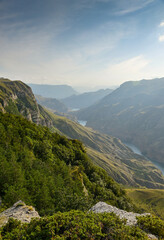 Naklejka premium A beautiful landscape of mountains with bushes, rocks and a blue river on a summer day. Sulak Canyon.