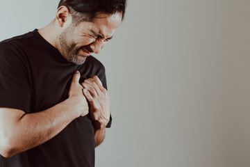 Photo of person clutching chest in pain. Concept of diseases, cardiac arrest, heart pain, health.