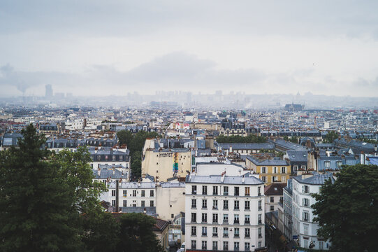 Parisian cityscape, with typical Parisian architecture and landmarks like the sa creu coeur and the Eiffel Tower can be seen. The picture was taken near the square pigalle.