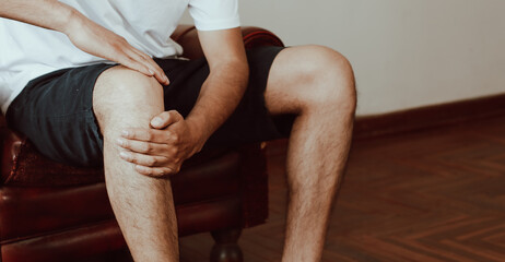 Photo of hands trying to soothe knee pain. Concept of health problems.