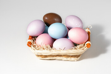 Basket with easter eggs on white background