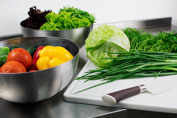 Fresh vegetables in a stainless steel bowl ready for cutting with a knife
