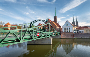 Side view of Tumski bridge in Wroclaw with churches and water reflections
