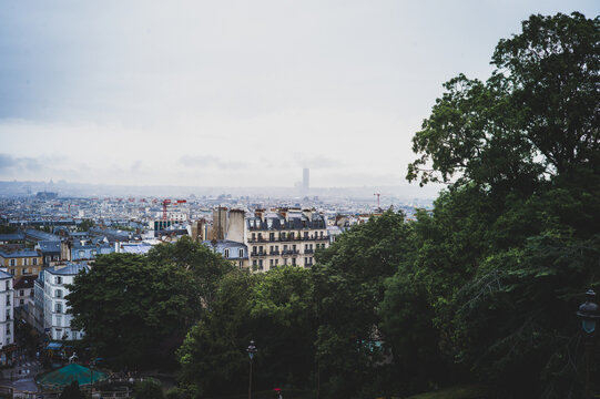 Parisian cityscape, with typical Parisian architecture and landmarks like the sa creu coeur and the Eiffel Tower can be seen. The picture was taken near the square pigalle.