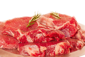 Beef steaks on a metal plate. Meat for cooking with rosemary isolated on white.