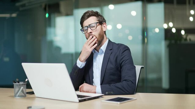Bored business man in office Sleeping sleepy yawning boredom at workplace indoors Tired Exhausted Businessman entrepreneur in formal suit Portrait Depressed, unhappy, workless male manager workplace